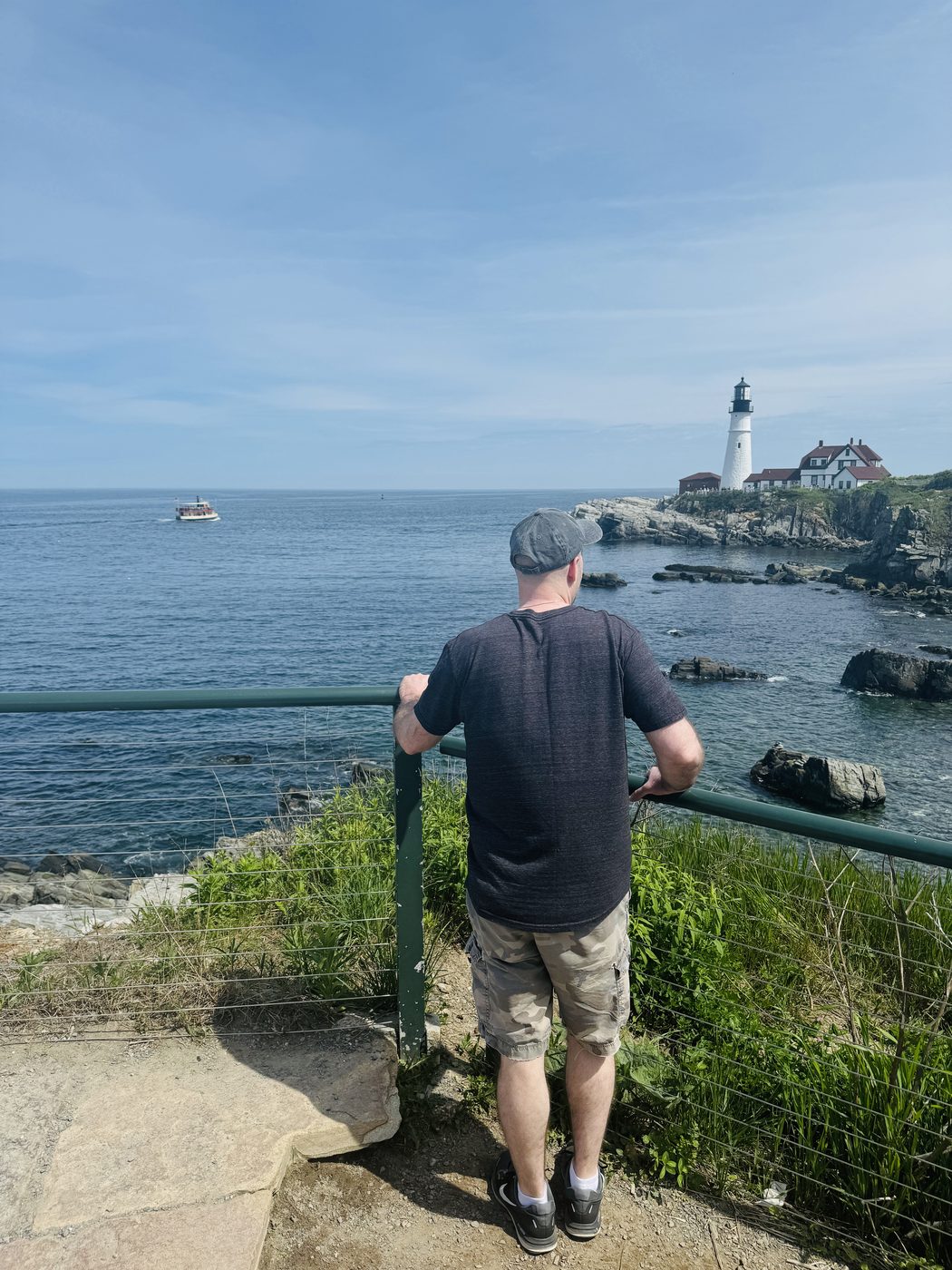 Brian Jacobsen looking out at the Maine coast, with Portland Head Light in the distance
